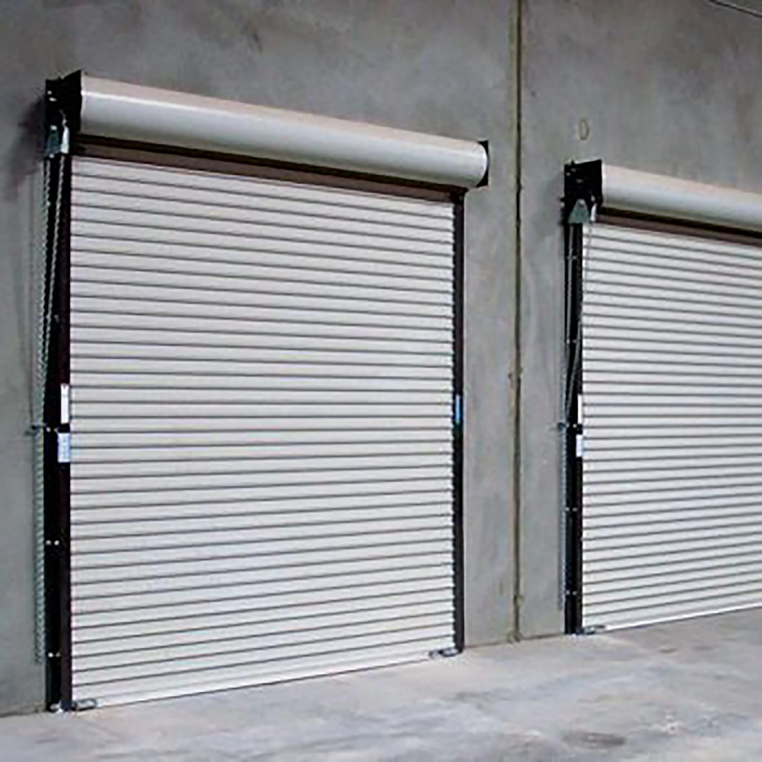 Two sleek commercial garage doors installed at a modern warehouse, showcasing durable industrial design and smooth operation.