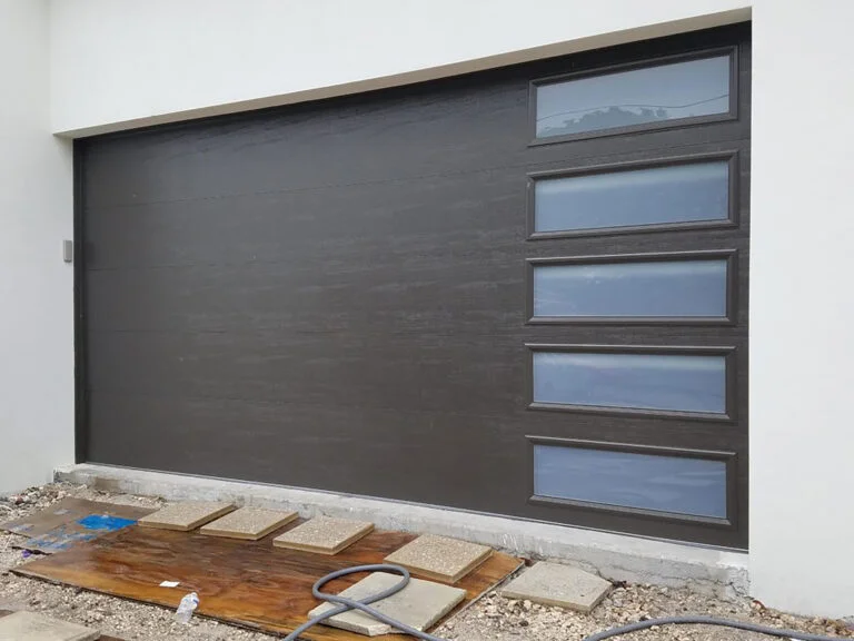 Dark gray garage door with vertical glass panels on the right side.